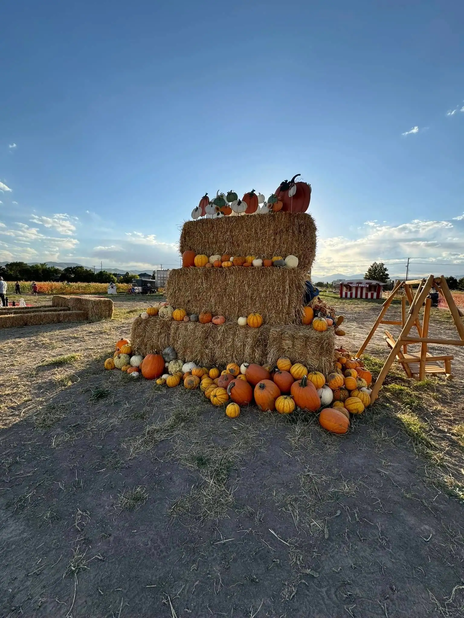 Three-tier hay-bale pyramid ringed with pumpkins at the Riverton patch