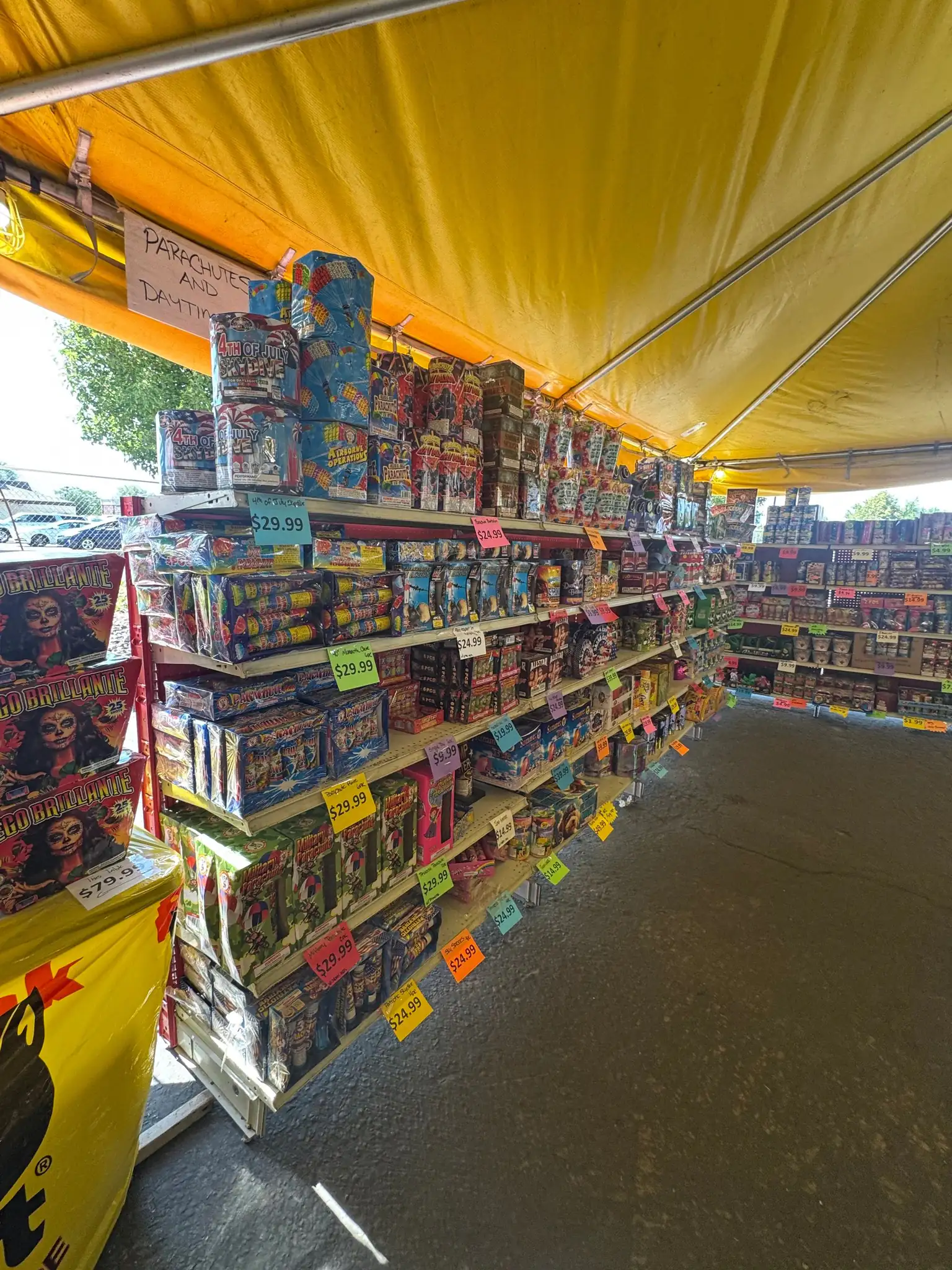 Shelves of aerials and parachute fireworks with hand-written price tags on every row