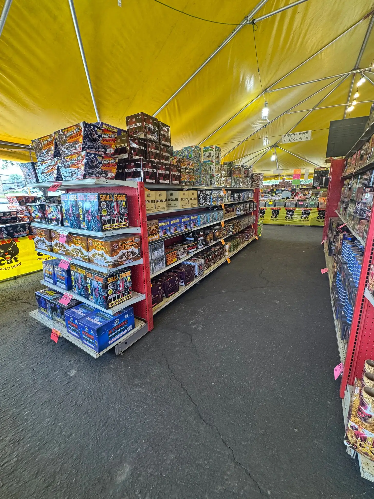 Racks of multi-shot cakes and aerials stacked to the tent roof